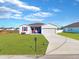 Newly built home with a two-car garage and a well-manicured lawn at 905 Desmoines Way, Poinciana, FL 34759