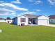 Gray house with red shutters, landscaping, and detached shed at 905 Desmoines Way, Poinciana, FL 34759