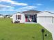 Newly constructed home with a two-car garage and landscaped lawn at 905 Desmoines Way, Poinciana, FL 34759