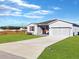 Gray house with red door and shutters, landscaped lawn, and driveway at 905 Desmoines Way, Poinciana, FL 34759