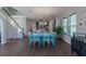 Bright dining room features a teal table with white chairs and hardwood floors at 10415 Austrina Oak Loop, Winter Garden, FL 34787