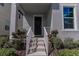 House entrance with dark brown door, white railings, and neat landscaping at 10415 Austrina Oak Loop, Winter Garden, FL 34787