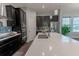 Sleek kitchen with white countertops, dark cabinetry, and stainless steel appliances at 10415 Austrina Oak Loop, Winter Garden, FL 34787