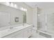 Modern bathroom with double vanity, large mirror, and shower at 1066 Quaker Ridge Ln, Davenport, FL 33896