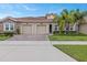 Two-car garage, attractive landscaping, and a brick facade at 1066 Quaker Ridge Ln, Davenport, FL 33896