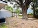 Large backyard with a big tree, wooden fence, and pergola at 1504 Hummingbird Ln, Lakeland, FL 33801