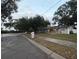Gray house with black door and a large tree in the front yard at 1504 Hummingbird Ln, Lakeland, FL 33801