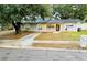 Newly painted gray house with a black door and mature landscaping at 1504 Hummingbird Ln, Lakeland, FL 33801