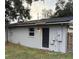 Gray house back with a black door and a side yard at 1504 Hummingbird Ln, Lakeland, FL 33801