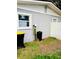 Gray house side with a window, water filtration system, and trash cans at 1504 Hummingbird Ln, Lakeland, FL 33801