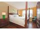 King-size bed with wooden frame in a bright bedroom at 160 Hideaway Beach Ln, Kissimmee, FL 34746
