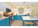 Bright kitchen features teal cabinets, stainless steel appliances, and an island with seating at 160 Hideaway Beach Ln, Kissimmee, FL 34746