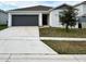 Single-story house with gray garage door and a well-maintained lawn at 1655 Aspen Ave, Davenport, FL 33837