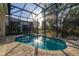 Inviting screened pool area with patio and lush landscaping at 1867 Flora Pass Pl, Kissimmee, FL 34747