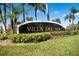 Villa Del Sol community entrance sign with lush landscaping at 2218 Grand Cayman Ct # 1335, Kissimmee, FL 34741