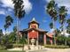 Community clubhouse with a fountain and palm trees at 2218 Grand Cayman Ct # 1335, Kissimmee, FL 34741