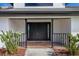 Modern home exterior featuring a black double front door and a covered entryway at 265 E Lake Shore Blvd, Kissimmee, FL 34744