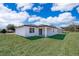 A bright, modern home with a pristine backyard, covered patio, and lush green lawn under a sunny sky at 2849 Sw 137Th Ln, Ocala, FL 34473