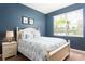 Bedroom with a queen-size bed and blue walls at 2950 Buccaneer Palm Rd, Kissimmee, FL 34747