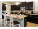 Kitchen with dark cabinets, granite counters and island at 2950 Buccaneer Palm Rd, Kissimmee, FL 34747