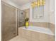 Spa-like bathroom with soaking tub, shower, and tile flooring at 370 Burma St, Kissimmee, FL 34747