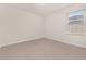 Bright bedroom featuring a window with blinds and carpet flooring at 370 Burma St, Kissimmee, FL 34747