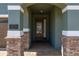 Front entry with a stone archway and a dark brown door at 370 Burma St, Kissimmee, FL 34747