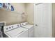 Functional laundry room with washer, dryer, and shelving at 573 Villa Park Rd, Poinciana, FL 34759