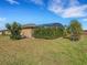 Landscaped backyard with privacy hedge and mature trees at 580 Cantabria Dr, Davenport, FL 33837