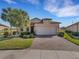 House exterior with a brick driveway and palm trees at 580 Cantabria Dr, Davenport, FL 33837