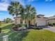 House exterior featuring palm trees and a paved driveway at 580 Cantabria Dr, Davenport, FL 33837