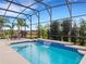 Inviting pool area with a water feature and screened enclosure at 580 Cantabria Dr, Davenport, FL 33837