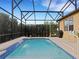 Refreshing pool with a waterfall feature and screened enclosure at 580 Cantabria Dr, Davenport, FL 33837