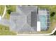 Top-down view of a house showcasing its roofline, pool, and screened enclosure at 605 Pinehurst Ct, Kissimmee, FL 34758