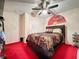 Bedroom with red carpet, ceiling fan, and a queen-size bed at 605 Pinehurst Ct, Kissimmee, FL 34758