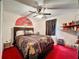 Bedroom with red carpet, ceiling fan, and a queen-size bed at 605 Pinehurst Ct, Kissimmee, FL 34758
