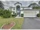 Two-story house with a large driveway and landscaped yard at 605 Pinehurst Ct, Kissimmee, FL 34758