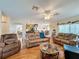 Living room with hardwood floors, leather furniture, and views into the kitchen and dining areas at 605 Pinehurst Ct, Kissimmee, FL 34758