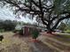 Side view of a brick ranch house with landscaping and oak tree at 802 Peters St, Wildwood, FL 34785