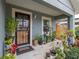 Charming front porch with decorative door and abundant potted plants at 1127 Avenue J, Haines City, FL 33844