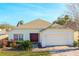 One-story house with a brown door, attached garage, and well-manicured lawn at 1201 Winding Willow Ct, Kissimmee, FL 34746