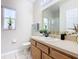 Clean bathroom with light wood vanity and a large mirror at 124 Cassia Dr, Davenport, FL 33897