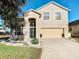 Two-story house with a two-car garage and landscaping at 124 Cassia Dr, Davenport, FL 33897