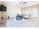 Living room with tiled floors, gray couch, and a large TV at 124 Cassia Dr, Davenport, FL 33897