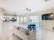 Open concept living room with kitchen, pool view, and tiled floors at 124 Cassia Dr, Davenport, FL 33897