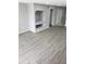 Bright living room with light gray walls, wood-look flooring, and a built-in shelving unit for storage or decor at 13803 Fairway Island Dr # S, Orlando, FL 32837