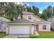 Two-story house with beige siding, attached garage, and landscaping at 152 Pinewood Dr, Davenport, FL 33896