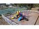 Aerial view of a playground in a fenced in area with mature landscaping at 1717 Clubhouse Cv, Haines City, FL 33844