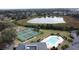 Aerial view of community pool, tennis courts, and lake surrounded by lush green trees at 1717 Clubhouse Cv, Haines City, FL 33844
