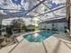 Inviting pool with a screen enclosure and a large patio for lounging and entertaining at 1717 Clubhouse Cv, Haines City, FL 33844